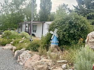 View of front of property featuring view of wooded area