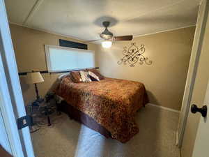 Carpeted bedroom featuring a ceiling fan and wooden walls