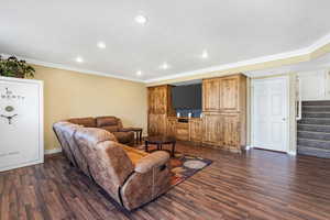 Living area featuring ornamental molding, recessed lighting, dark wood-type flooring, stairway, and a textured ceiling