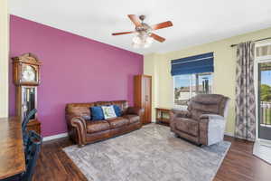 Living area featuring dark wood finished floors and a ceiling fan