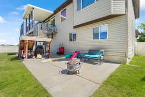 Back of house with a balcony, an outdoor fire pit, and a patio