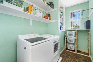 Laundry room featuring washing machine and dryer and baseboards