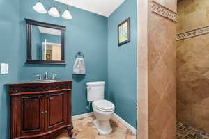 Full bathroom with vanity, a tile shower, and light tile patterned floors