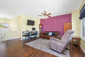 Living room featuring healthy amount of natural light, dark wood-style flooring, and a ceiling fan