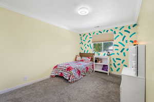 Carpeted bedroom featuring crown molding
