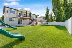 Rear view of house featuring a playground, a patio area, and a trampoline