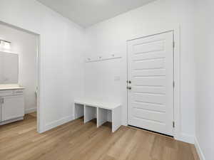 Mudroom featuring light wood finished floors and baseboards