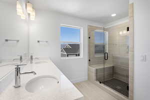 Full bathroom with double vanity, a stall shower, and recessed lighting