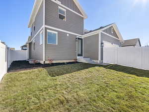 Rear view of house featuring board and batten siding, a fenced backyard, a gate, and an attached garage