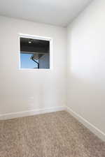 Carpeted empty room with baseboards