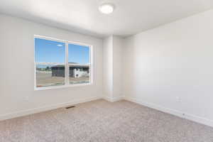 Spare room with baseboards and carpet flooring