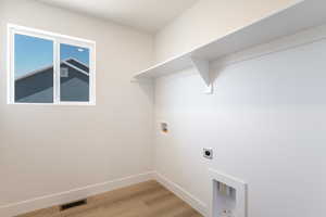 Laundry room featuring hookup for a washing machine, light wood-style flooring, and electric dryer hookup