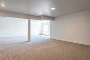 Basement with carpet floors and a textured ceiling