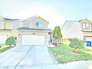 Traditional-style home with stucco siding, an attached garage, concrete driveway, and stone siding