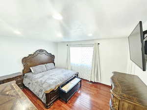 Bedroom with wood-type flooring and baseboards