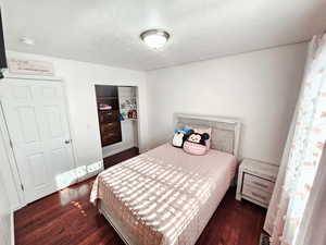 Bedroom featuring dark wood finished floors and a closet