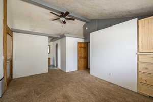Unfurnished bedroom featuring carpet flooring, a ceiling fan, and a textured ceiling