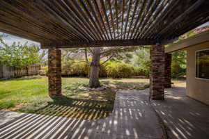 Fenced backyard with a pergola and a patio