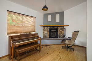 Living area with light wood finished floors and a stone fireplace