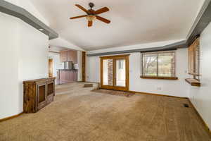 Unfurnished living room featuring light carpet and a ceiling fan