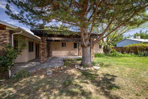 Back of house featuring a pergola, stucco siding, a patio, and stone siding