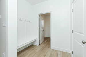 Mudroom with light wood-type flooring and baseboards