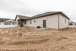 Rear view of house featuring a patio and roof with shingles