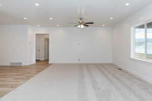 Spare room with recessed lighting, a ceiling fan, light wood-style flooring, and light colored carpet