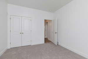 Unfurnished bedroom featuring carpet floors and a closet