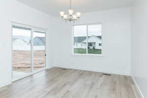 Unfurnished dining area with light wood-type flooring and a chandelier