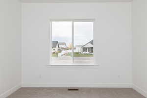 Carpeted empty room with baseboards