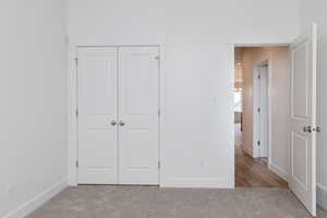 Unfurnished bedroom featuring carpet flooring and a closet