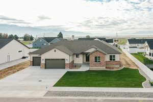 View of front of house with driveway, a garage, a shingled roof, and board and batten siding