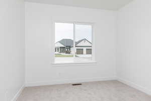 Empty room featuring carpet and baseboards