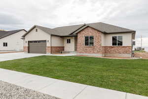 View of front of property with roof with shingles, a garage, concrete driveway, and a front yard