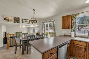 Kitchen with a peninsula, healthy amount of natural light, dishwasher, brown cabinets, and vaulted ceiling