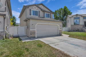 View of front facade with concrete driveway, a garage, a gate, and stucco siding