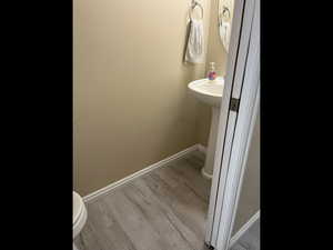 Half bath with baseboards and light wood-style floors