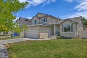 Traditional-style home featuring stucco siding, driveway, a garage, solar panels, and stone siding