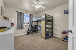 Bedroom featuring light carpet, a ceiling fan, and a textured ceiling