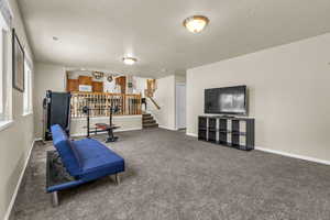 Sitting room with carpet flooring, a textured ceiling, and stairway