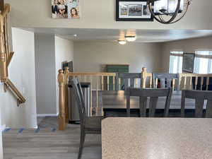 Dining area with a chandelier, light wood finished floors, and a textured ceiling