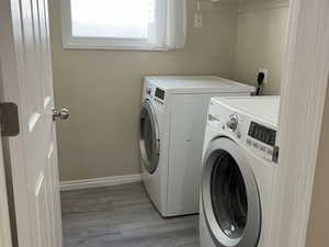 Laundry area featuring light wood-type flooring and independent washer and dryer
