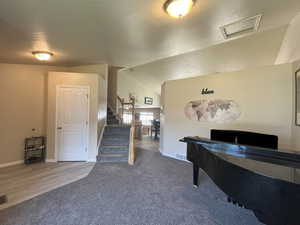 Playroom featuring lofted ceiling, a textured ceiling, and carpet floors