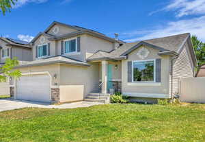 View of front of house with stucco siding, a garage, stone siding, concrete driveway, and a shingled roof