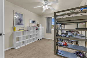 Bedroom with light carpet and a ceiling fan