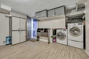 Laundry room with a textured ceiling and washer and dryer