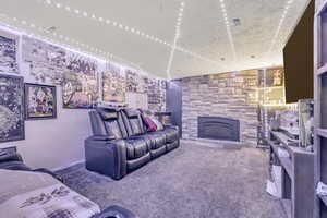 Carpeted living area with a stone fireplace
