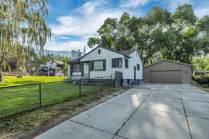 Bungalow featuring a detached garage, an outbuilding, a chimney, and a mountain view