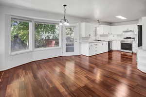 Kitchen featuring hanging light fixtures, dark wood-style floors, and white cabinets